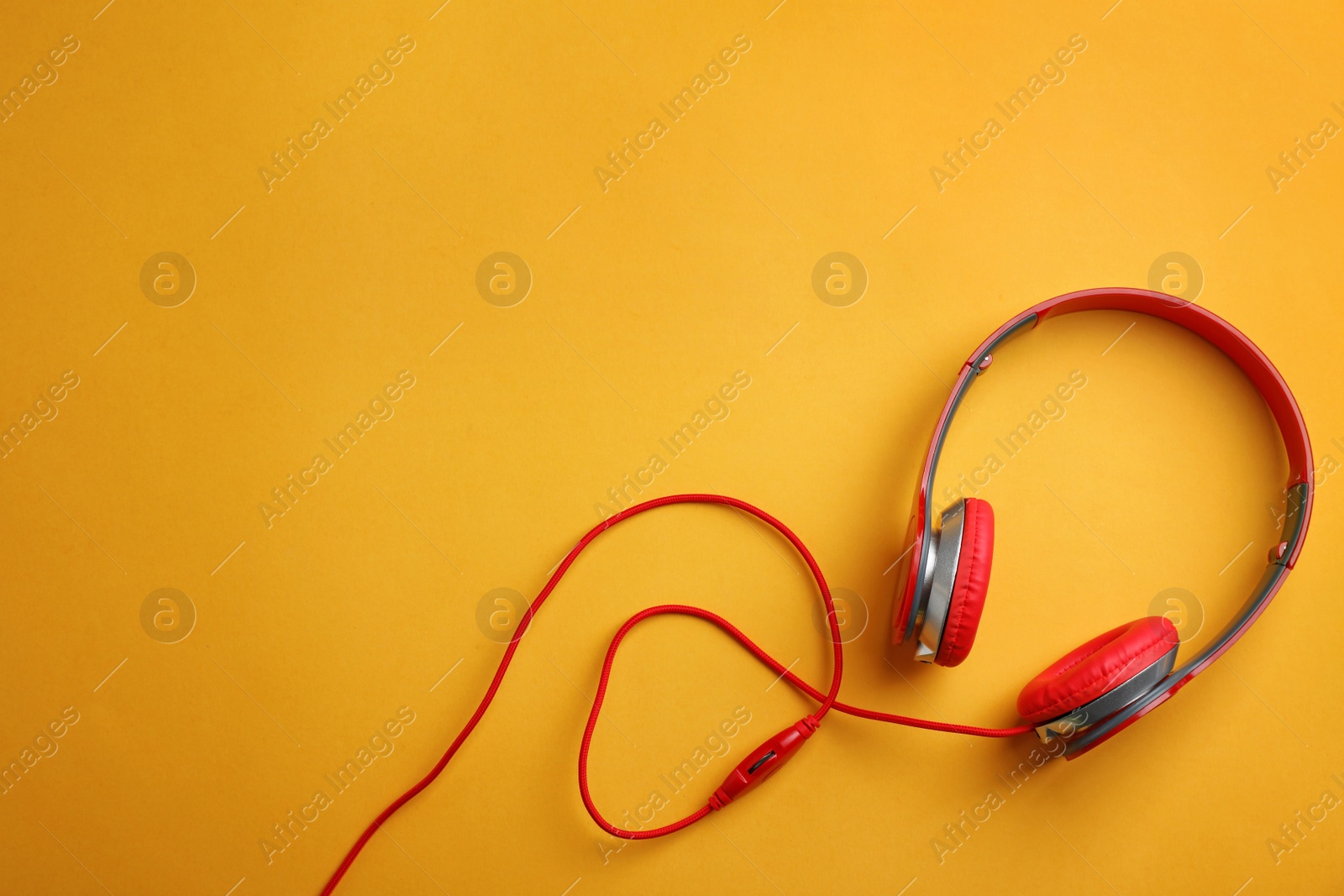 Photo of Stylish headphones on color background, top view. Space for text