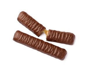 Sweet tasty chocolate bars with caramel on white background, top view