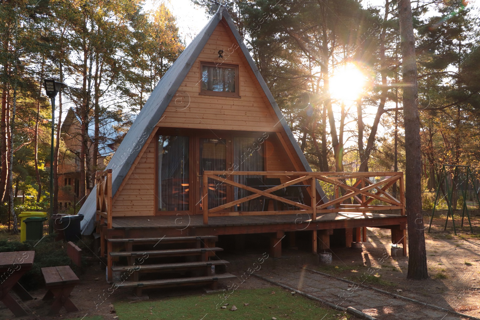 Photo of Picturesque view of modern wooden house with veranda near forest on sunny day