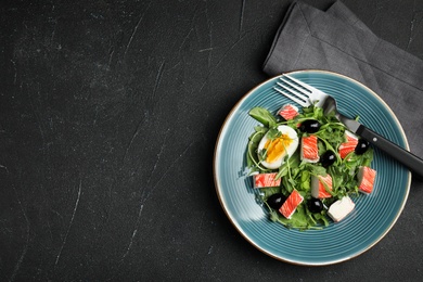 Delicious crab stick salad served on black table, flat lay. Space for text