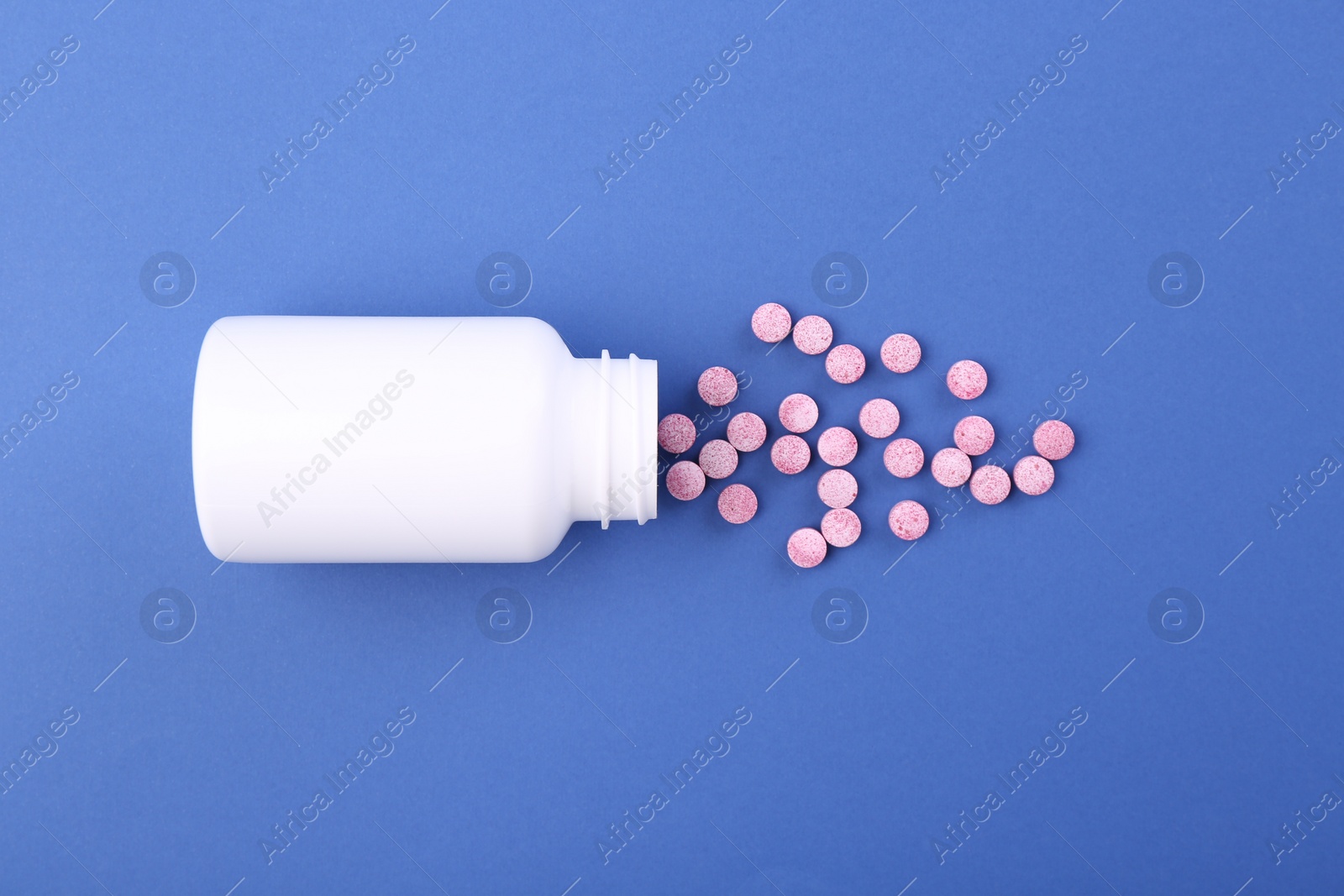 Photo of Bottle and vitamin pills on blue background, top view