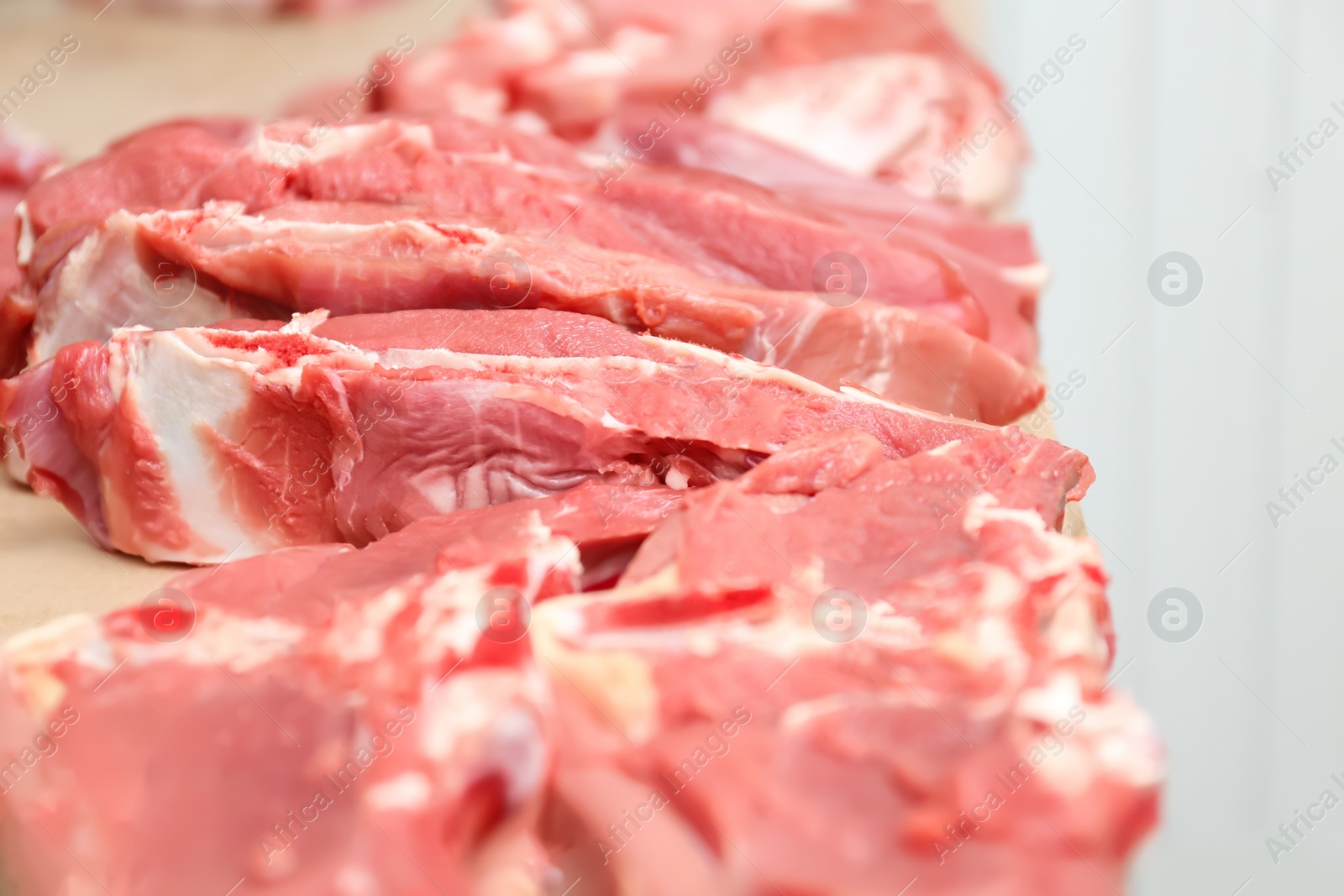 Photo of Pieces of fresh raw meat on counter in butcher shop