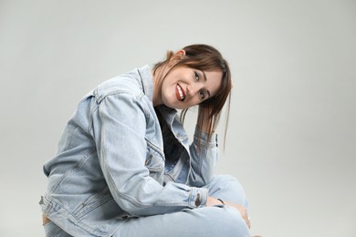 Portrait of happy woman on grey background