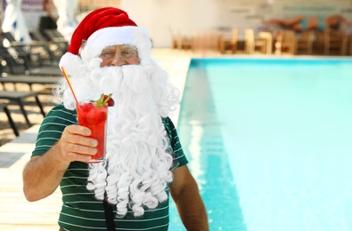 Authentic Santa Claus with cocktail near pool at resort