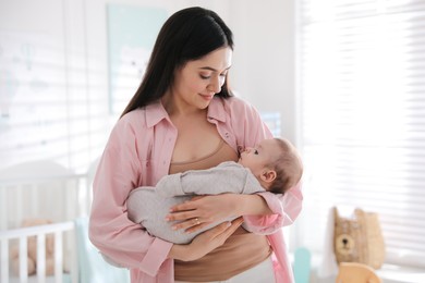 Photo of Young woman with her cute baby at home