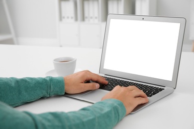 Young man working with modern laptop at table, closeup. Mockup for design