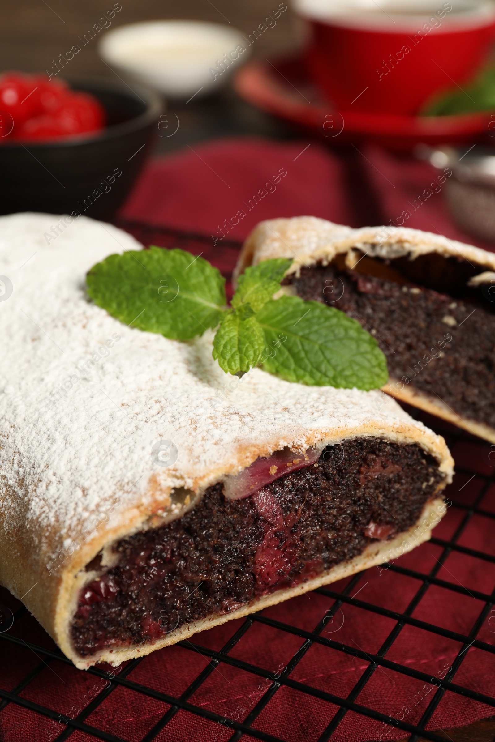 Photo of Delicious strudel with cherries and poppy seeds on table, closeup