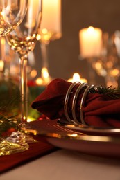 Photo of Christmas place setting with tableware and napkin on table, closeup