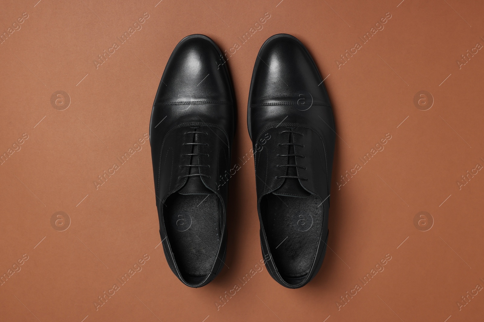 Photo of Pair of leather men shoes on brown background, top view