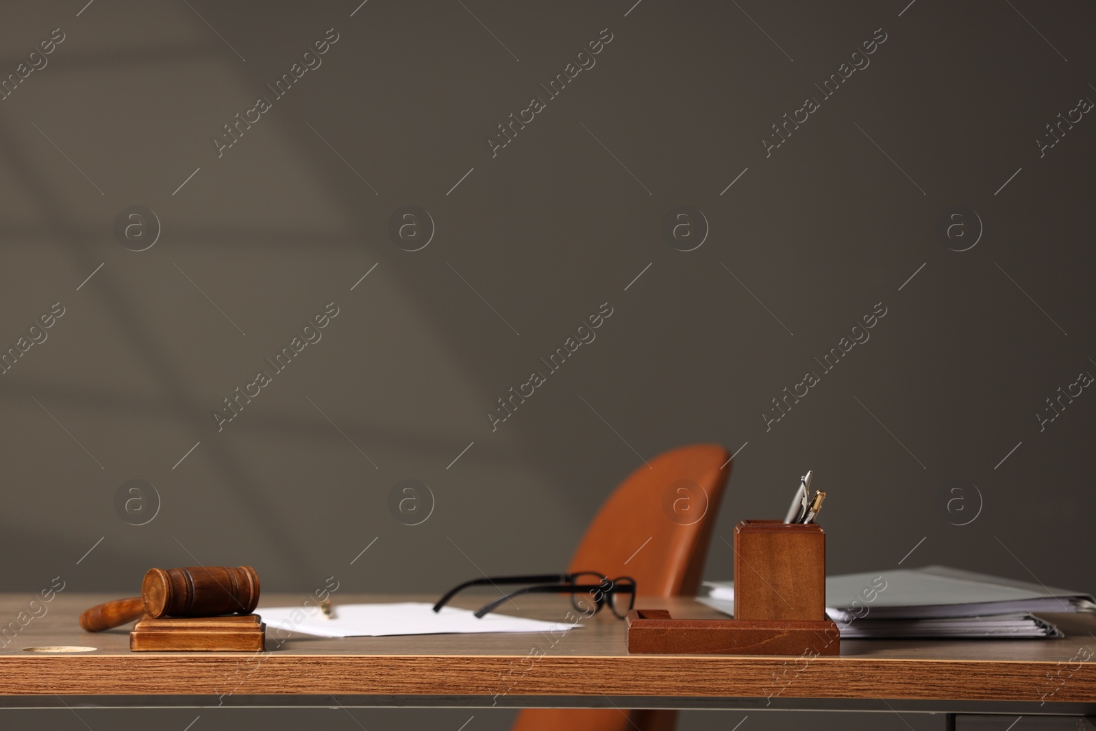 Photo of Judge's workplace with documents, table, chair and mallet. Space for text