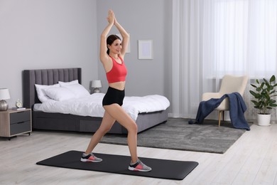 Happy woman doing morning exercise at home