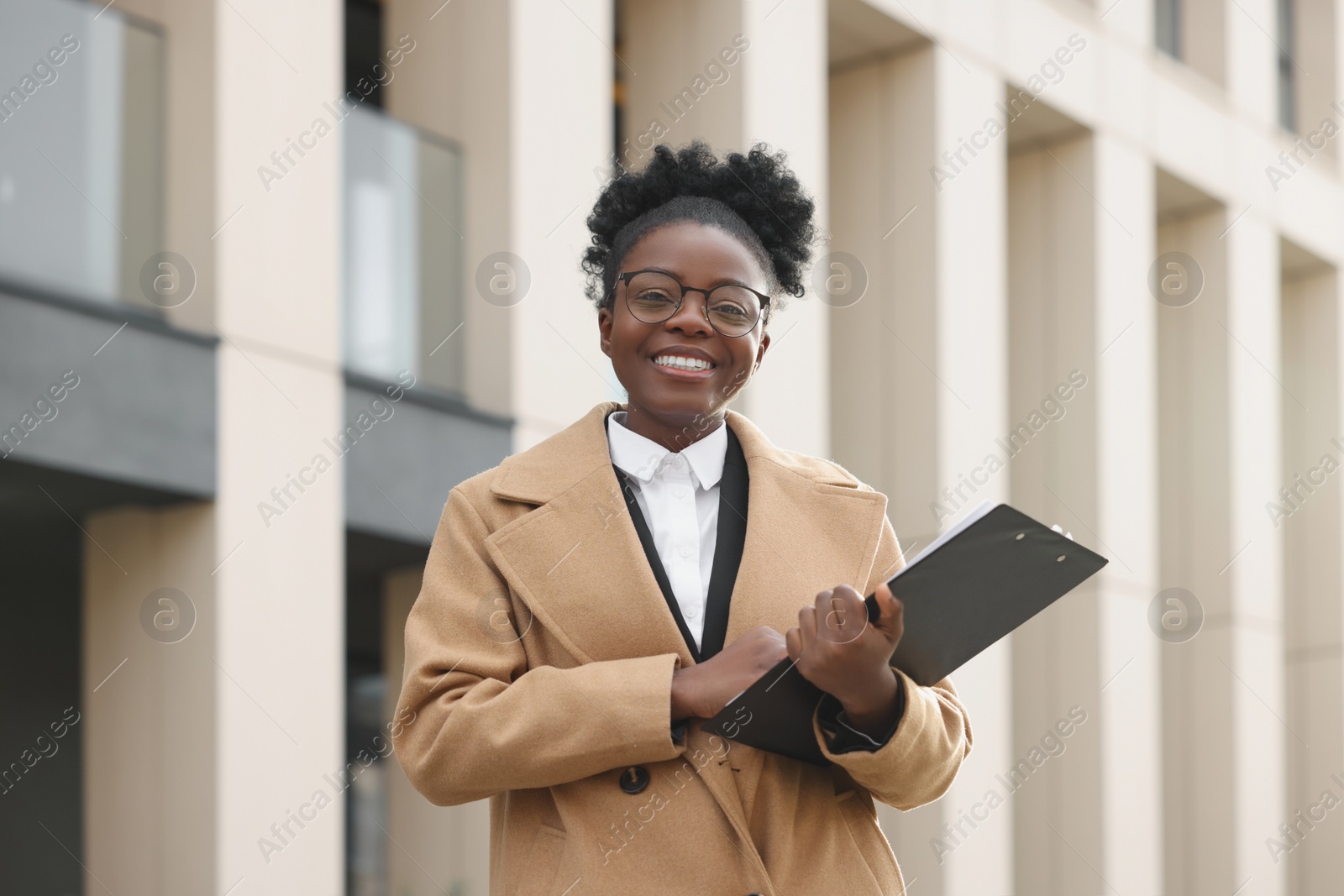 Photo of Happy woman with clipboard outdoors. Lawyer, businesswoman, accountant or manager