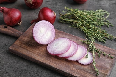 Wooden board with sliced red onion on table, closeup