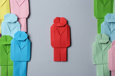 Photo of Many colorful paper figures on grey background, flat lay. Recruiter searching employee