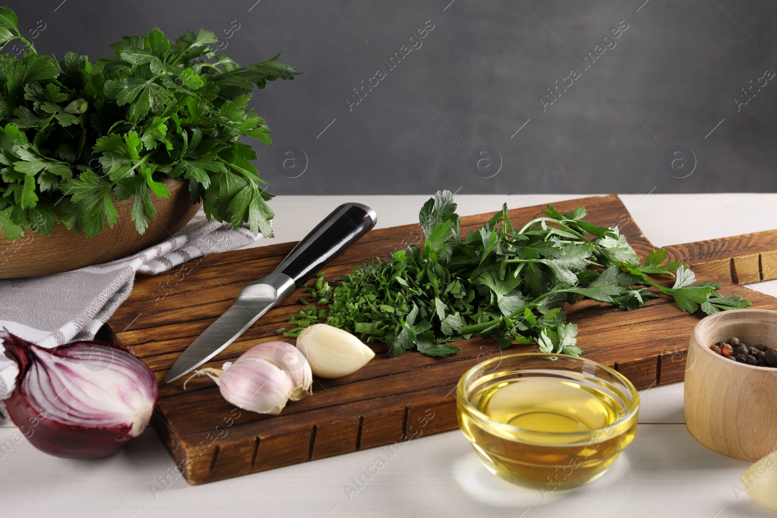 Photo of Fresh green parsley and different products on white wooden table