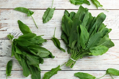 Photo of Fresh green sorrel leaves on white wooden table, flat lay