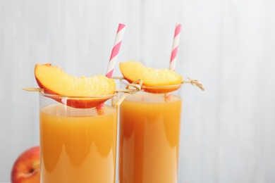Photo of Glasses of natural peach juice with fruit slices, closeup