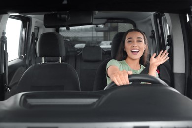 Photo of Listening to radio. Beautiful woman enjoying music in car, view through windshield