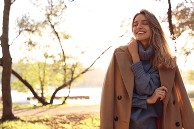 Photo of Beautiful young woman wearing stylish clothes in autumn park