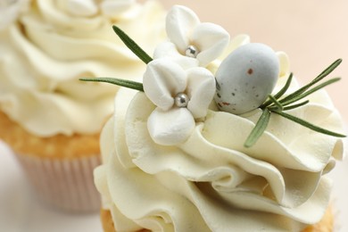 Photo of Tasty Easter cupcakes with vanilla cream on table, closeup