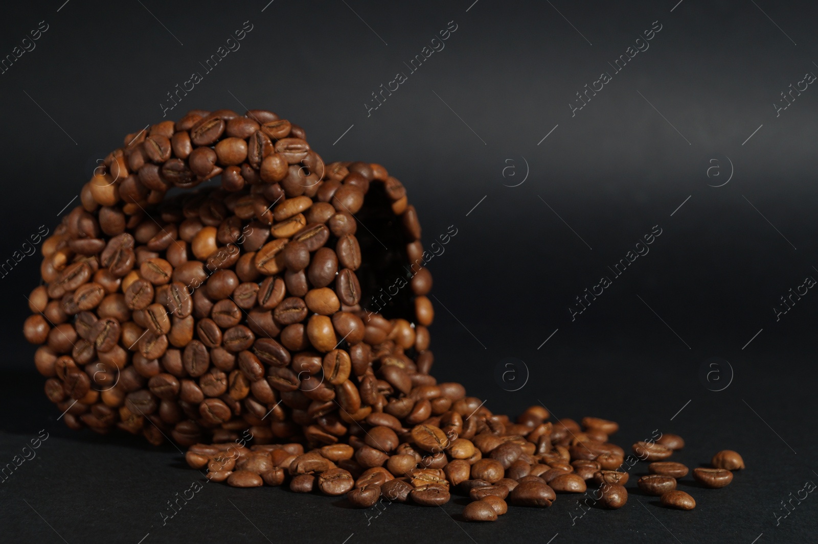 Photo of Cup made of coffee beans against black background