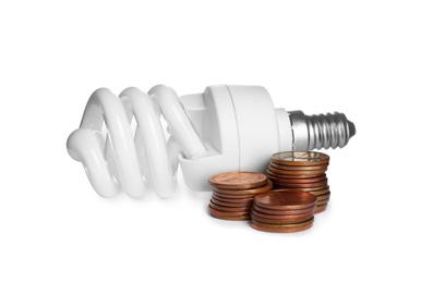 Photo of Lamp bulb and coins on white background. Money saving concept