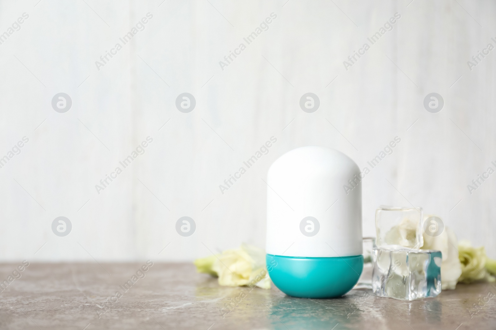 Photo of Deodorant and ice cubes on marble table