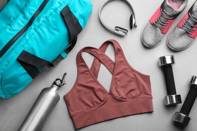 Photo of Flat lay composition with gym bag and sportswear on grey table