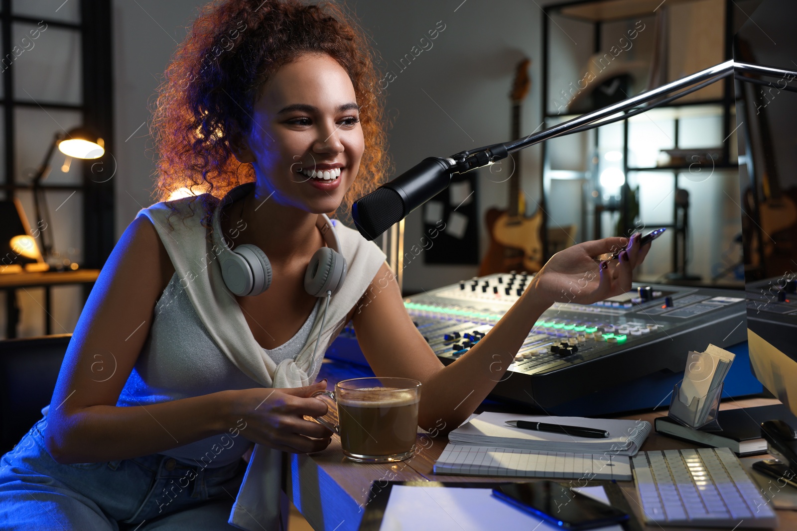 Photo of African American woman working as radio host in modern studio