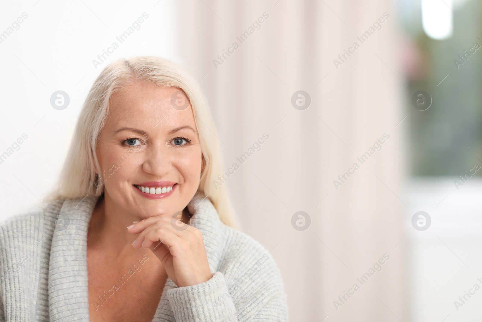 Photo of Portrait of beautiful older woman against blurred background with space for text