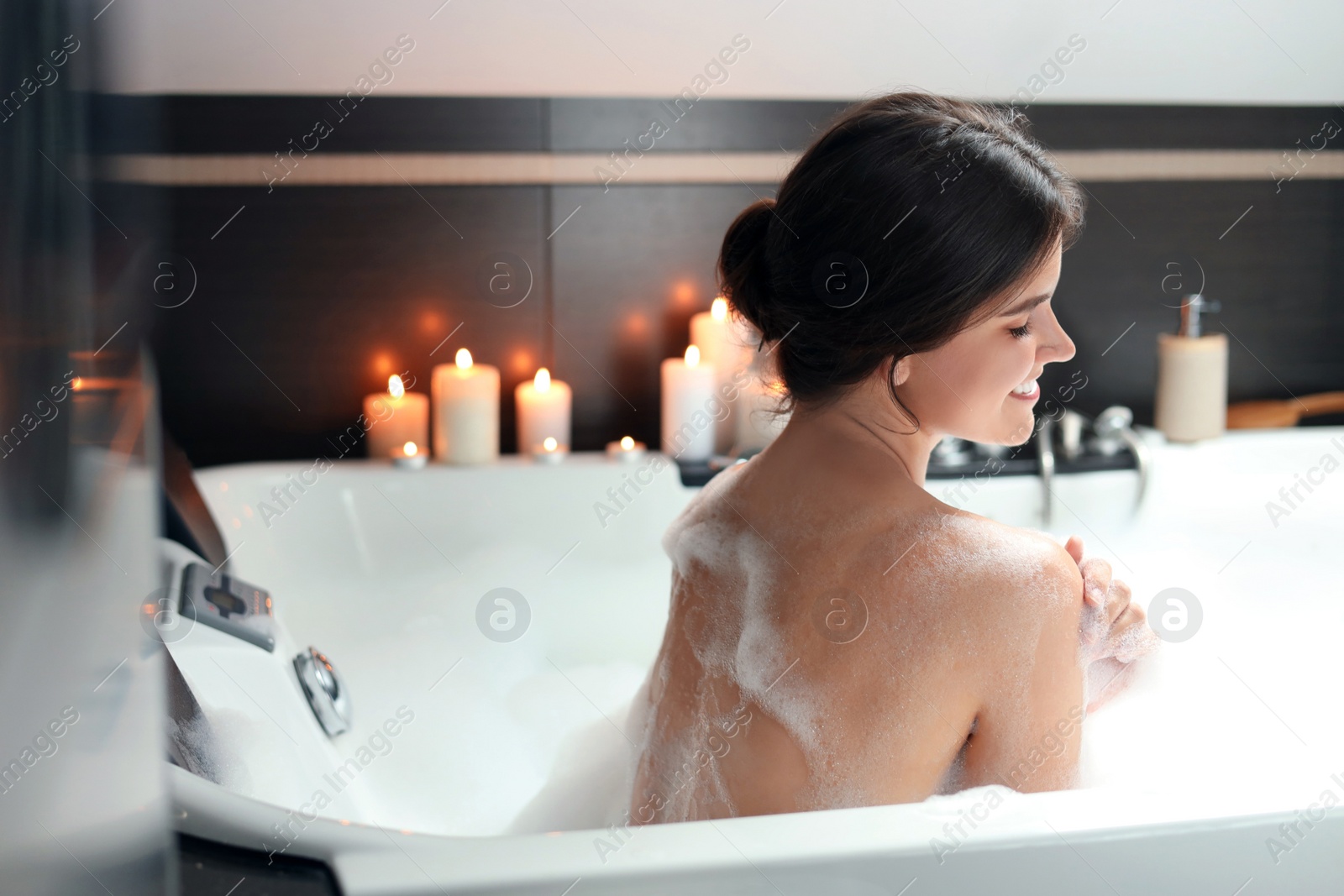 Photo of Happy beautiful woman taking bubble bath. Romantic atmosphere