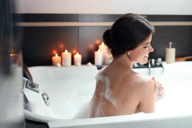 Happy beautiful woman taking bubble bath. Romantic atmosphere