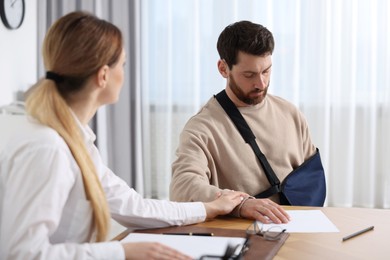 Injured woman having meeting with lawyer in office