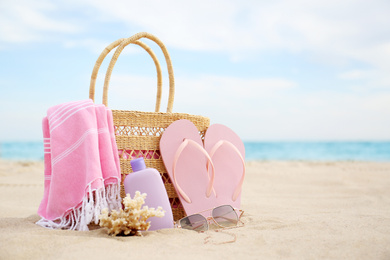 Photo of Different stylish beach objects and coral on sand near sea. Space for text