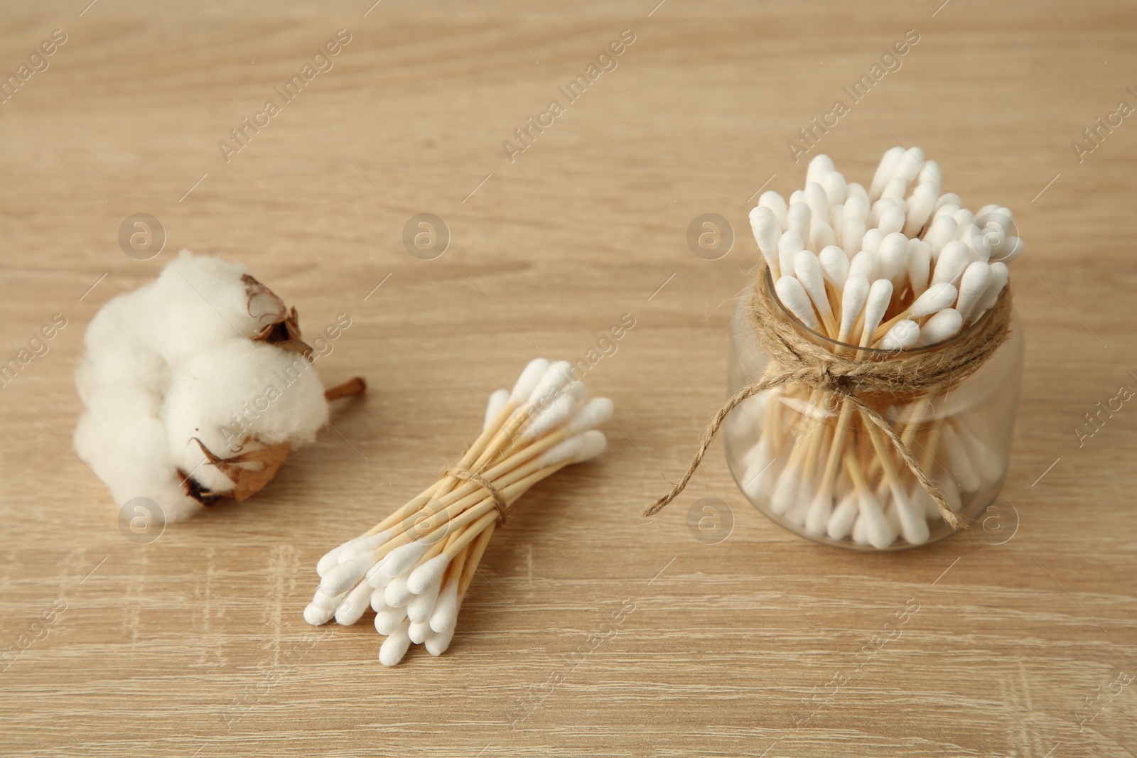 Photo of Cotton swabs and flower on wooden table