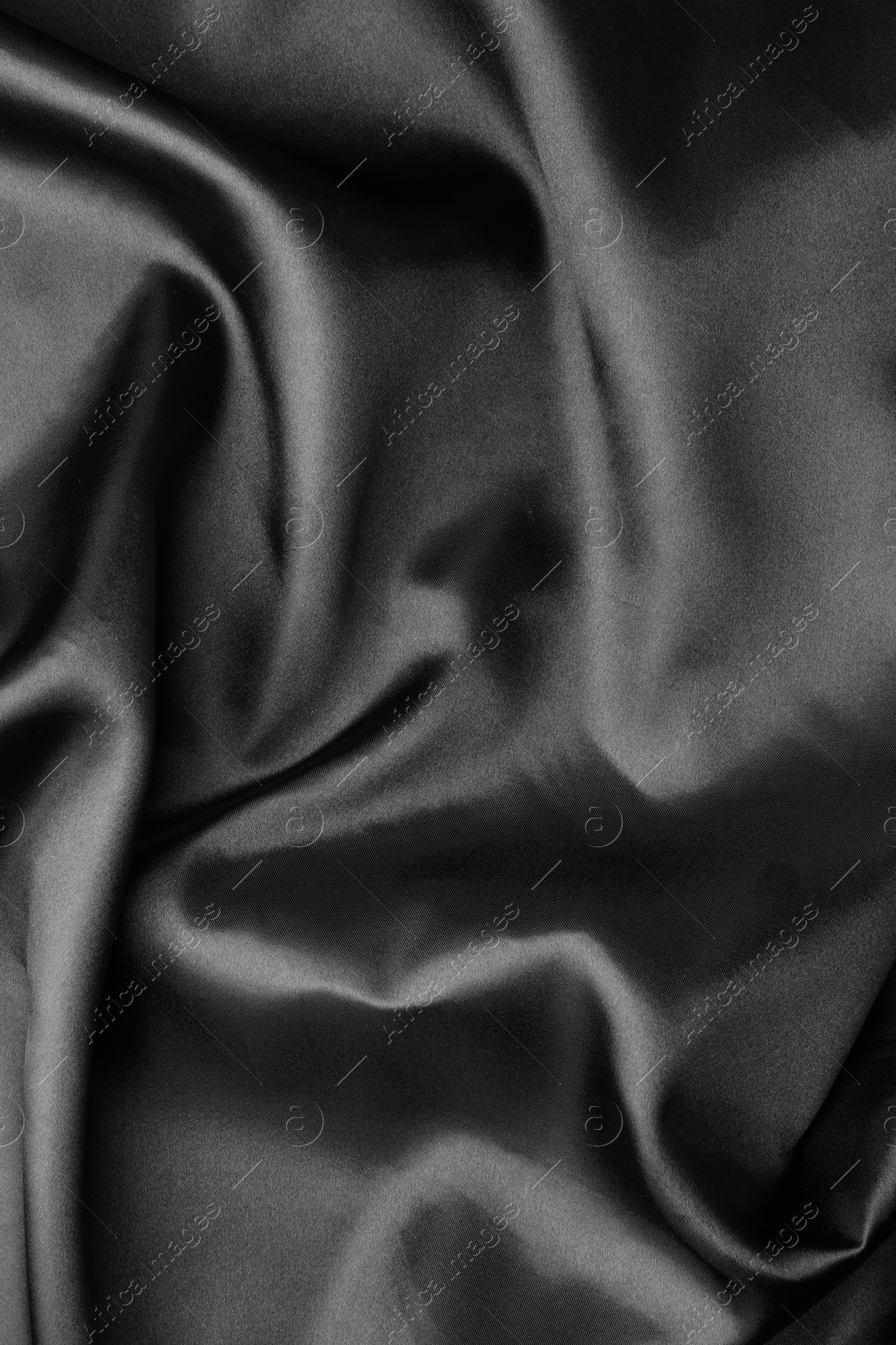 Photo of Crumpled black silk fabric as background, top view