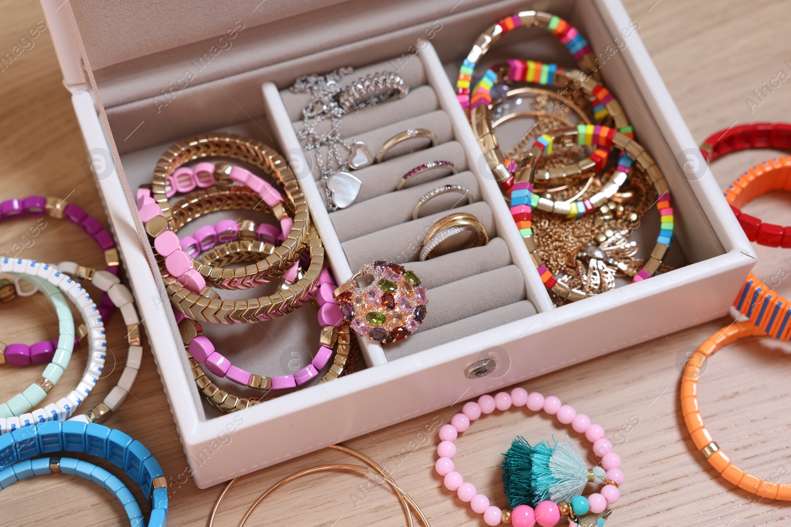 Photo of Jewelry box with stylish bracelets and other accessories on wooden table