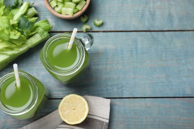 Photo of Celery juice and fresh ingredients on blue wooden table, flat lay. Space for text