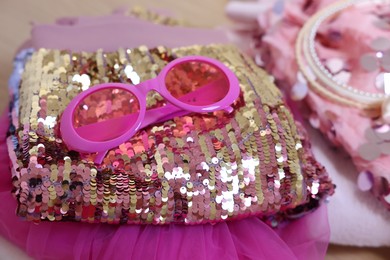 Photo of Stylish carnival costume with sequins, sunglasses and headbands, closeup