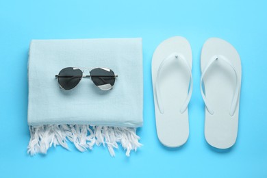 Flat lay composition with different beach objects on light blue background