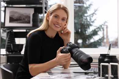 Photo of Professional photographer with digital camera at table in office