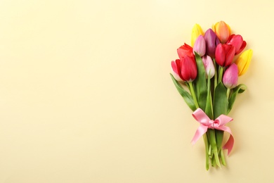 Photo of Beautiful bouquet of spring tulip flowers on color background, top view. Space for text