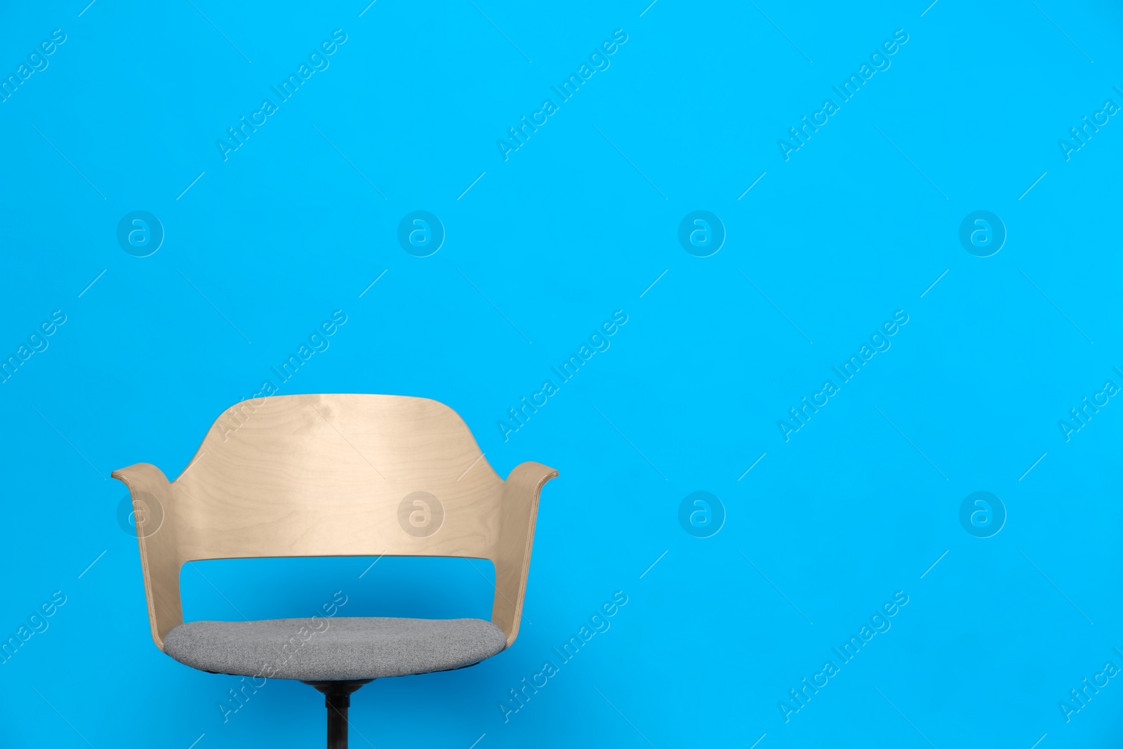 Photo of Comfortable office chair on light blue background, space for text