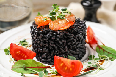 Photo of Delicious black risotto with seafood served on plate, closeup