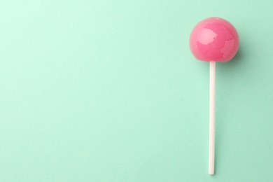 Tasty lollipop on turquoise background, top view. Space for text