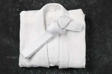 White karate belt and kimono on gray background, top view