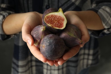 Photo of Woman holding tasty raw figs, closeup view