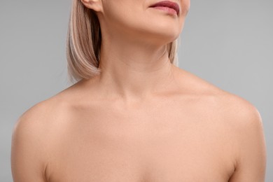 Woman with healthy skin on grey background, closeup