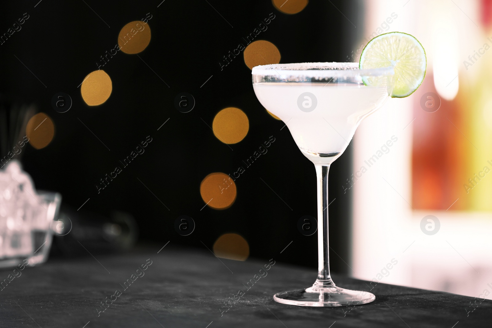 Photo of Fresh alcoholic cocktail with lemon and sugar on bar counter, space for text