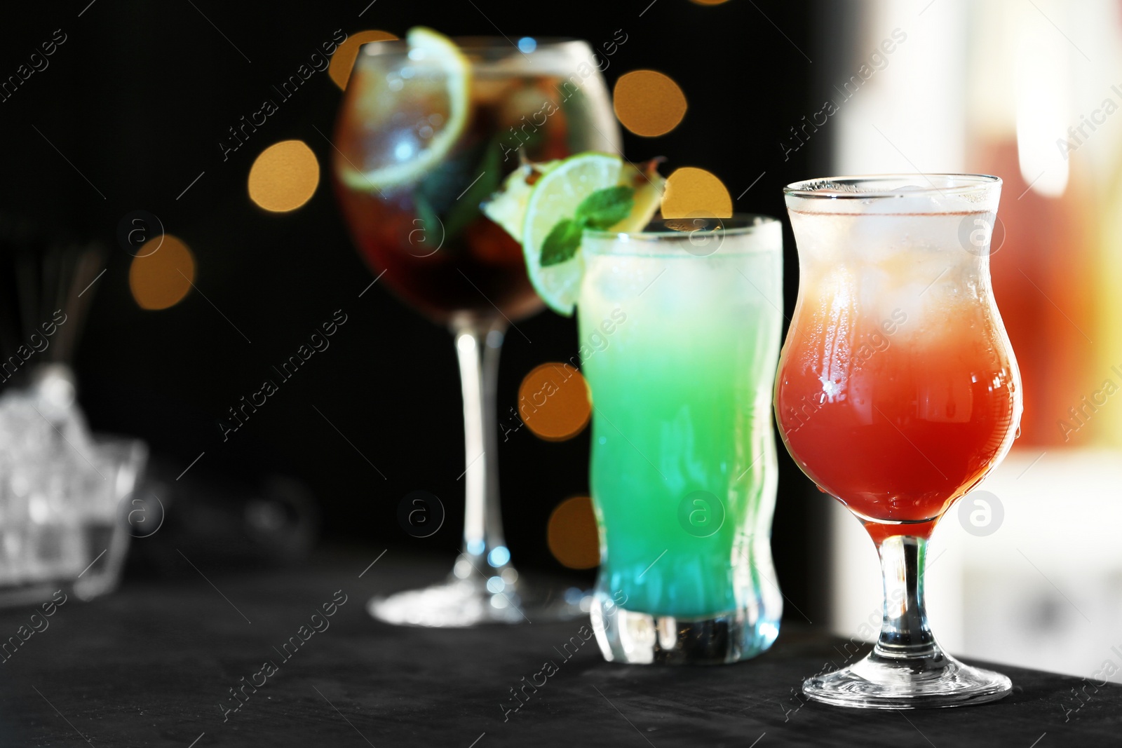 Photo of Row of different fresh alcoholic cocktails on bar counter